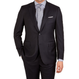 A man is posing for a picture in a Canali Navy Blue Wool Notch Lapel Suit with structured shoulders.