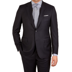 A man is posing for a picture in a Canali Navy Blue Wool Notch Lapel Suit with structured shoulders.