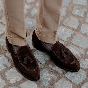 A pair of brown suede loafers with tassels