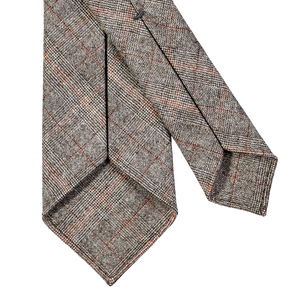 A Dreaming Of Monday Brown Checked 7-Fold Vintage Wool Tie on a grey background.