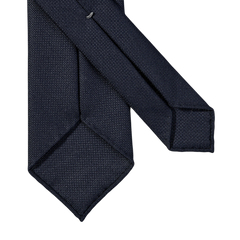 A Navy Blue 7-Fold Wool Hopsack Tie by Dreaming Of Monday with an elegant drape on a white background.