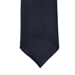 An elegant Navy Blue 7-Fold Wool Hopsack tie on a white background, handmade with unlined construction for a stylish and sophisticated drape from Dreaming Of Monday.