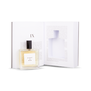 An Eight Bob Perfume Original 100 ml Inside Book rests on an open book.