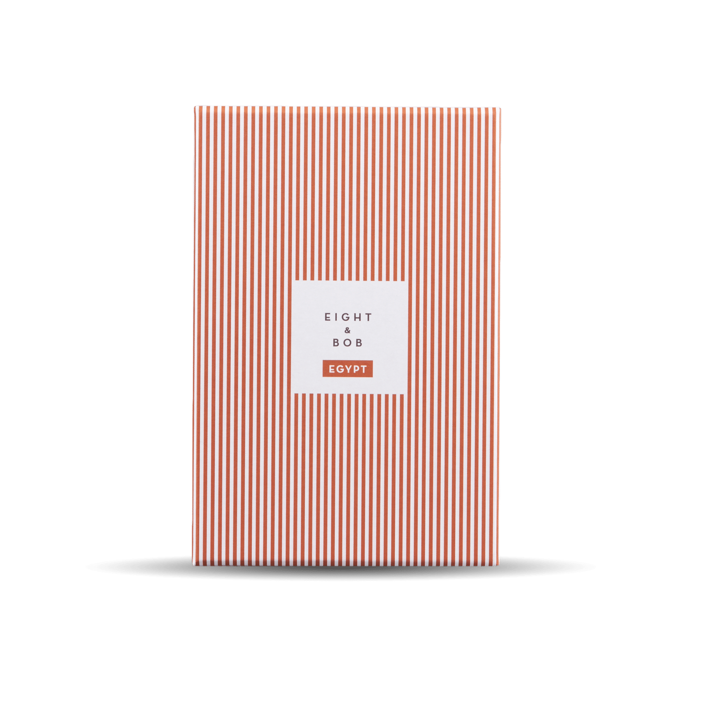 An orange and white striped Eight Bob notebook on a black background with a unique scent.