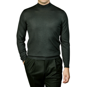 A man wearing a Green 140s Wool Mockneck Sweater made by Fedeli.