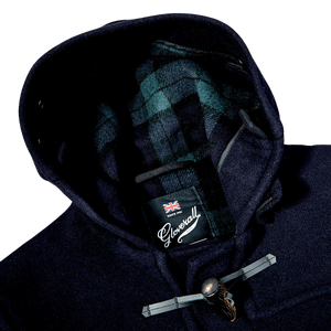 A Gloverall Navy Blue Wool Morris Duffle Coat with a plaid label on the hood, made of Italian wool.