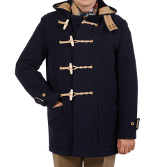 A boy wearing a Gloverall Navy Blue Wool Union Jack Monty Duffle coat in navy and tan, perfect for winter.