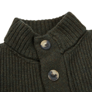 An Inis Meain Alpine Green Merino Wool Storm Jacket with buttons made from pure merino yarns.