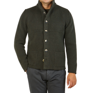A man wearing a luxurious Inis Meain Alpine Green Merino Wool Storm Jacket made with merino yarns.